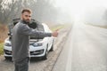 Sad driver having engine problem standing near broken car on the road. Car breakdown concept Royalty Free Stock Photo