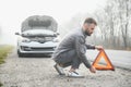 Sad driver having engine problem standing near broken car on the road. Car breakdown concept Royalty Free Stock Photo