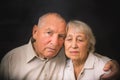 Sad elderly couple on a black background Royalty Free Stock Photo