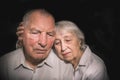 Sad elderly couple on a black background Royalty Free Stock Photo