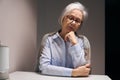 Sad elderly lady sits alone at a table Royalty Free Stock Photo