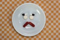 Sad face made of medicine. pain medication tablets. colored pills on porcelain dish. Assorted pharmaceutical pills