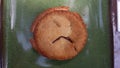 Sad face in mini cherry pie on a green plate Royalty Free Stock Photo