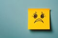 A sad face on a yellow sticker. Space for text. Royalty Free Stock Photo