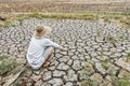 Sad farmer is sitting in a agricultural field during the long drought