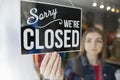 Sad Female Owner Of Small Business Turning Round Closed Sign In Shop Window Royalty Free Stock Photo