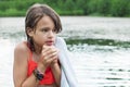 Sad froze teenage girl shivering after bathing in the lake in summer