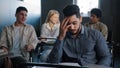 Sad frustrated arab student sitting in class at desk alone suffering from mistreatment by classmates racial