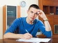 Sad frustrated guy filling out paperwork Royalty Free Stock Photo