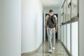 Sad frustrated teenage boy walks away down school corridor alone. Education difficulties, problem with family, emotion