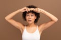 Sad funny millennial african american curly woman in white top combing with hairbrush Royalty Free Stock Photo