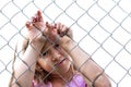 Sad girl behind metal wire mesh fence Royalty Free Stock Photo