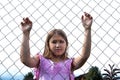 Sad girl behind metal wire mesh fence Royalty Free Stock Photo