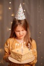 Sad girl with birthday cake. tradition to make wish and blow out fire Royalty Free Stock Photo