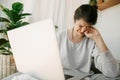 Sad girl crying from bad news, sitting with laptop home alone during quarantine. Young woman worries about losing job, depression