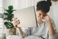 Sad girl crying from bad news from tablet while sitting home during quarantine. Young woman worries about losing job, depression