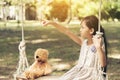 Sad girl feeling alone in the park. Lonely concepts. Beautiful toddler girl and fluffy stay alone under the big tree Royalty Free Stock Photo