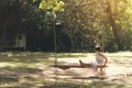 Sad girl feeling alone in the park. Lonely concepts. Beautiful toddler girl and fluffy stay alone under the big tree