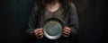 a sad girl holding a empty plate. poverty and hunger concept. beggar, begging.