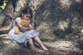Sad girl hugging teddy bear sitting under tree sadness alone in green park. Lonely girl feeling sad unhappy sit outdoors hug best Royalty Free Stock Photo