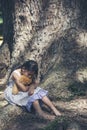 Sad girl hugging teddy bear sitting under tree sadness alone in green park. Lonely girl feeling sad unhappy sit outdoors hug best Royalty Free Stock Photo