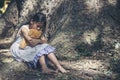 Sad girl hugging teddy bear sitting under tree sadness alone in green park. Lonely girl feeling sad unhappy sit outdoors hug best Royalty Free Stock Photo