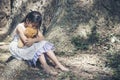 Sad girl hugging teddy bear sitting under tree sadness alone in green park. Lonely girl feeling sad unhappy sit outdoors hug best Royalty Free Stock Photo