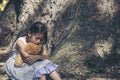 Sad girl hugging teddy bear sitting under tree sadness alone in green park. Lonely girl feeling sad unhappy sit outdoors hug best Royalty Free Stock Photo