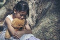 Sad girl hugging teddy bear sitting under tree sadness alone in green park. Lonely girl feeling sad unhappy sit outdoors hug best Royalty Free Stock Photo