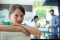 Sad girl leaning on chair while parents arguing in background Royalty Free Stock Photo