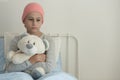 Sad girl with leukemia hugging plush toy in the hospital Royalty Free Stock Photo