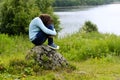 The sad girl with long hair sits on a stone. Concept depression Royalty Free Stock Photo