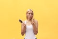 Sad girl looking at her damaged hair with comb in hand Royalty Free Stock Photo