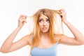 Sad girl looking at her dry hair Royalty Free Stock Photo