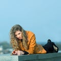 Sad girl lying down and reaching for a stack of coins