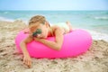 Sad girl lying on pink inflatable circle