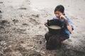 Sad girl praying for the rain on cracked dry ground