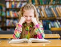 Sad girl reading a book in the library Royalty Free Stock Photo