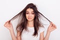 Sad girl showing her damaged hair while standing white background Royalty Free Stock Photo