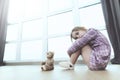 Sad Girl Sit with Teddy Bear on Floor Indoors Royalty Free Stock Photo