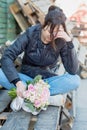 sad girl sits on a bench and holds a wedding bouquet. girl crying. broken love