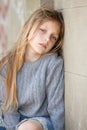 Sad girl sitting against the wall Royalty Free Stock Photo