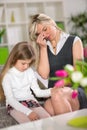 Sad girl sitting on sofa next worried mom