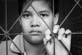 Sad girl standing alone behind jail bars Royalty Free Stock Photo