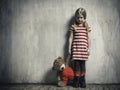 Sad girl with a toy bear on a background of textured walls. Royalty Free Stock Photo