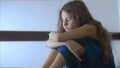 Sad girl upset embraces violence her feet. is depressed and suicidal little lamentable girl schoolgirl sadness misses