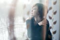 Sad girl on windowsill looking out the window Royalty Free Stock Photo