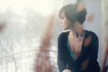 Sad girl on windowsill looking out the window Royalty Free Stock Photo