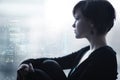 Sad girl on windowsill looking out the window Royalty Free Stock Photo