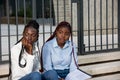 Sad girls sitting on city stairs and thinking Royalty Free Stock Photo